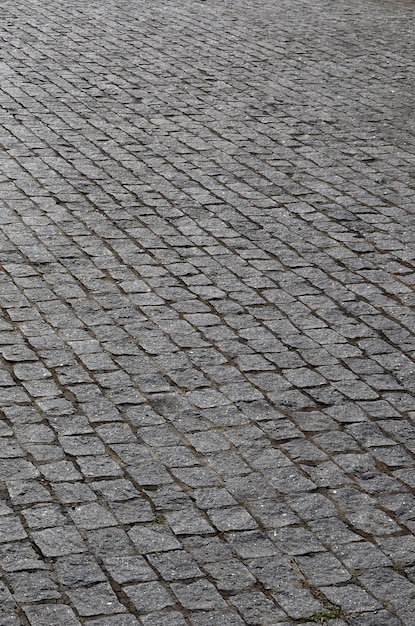 La textura de la losa de pavimento (adoquines) de muchas piedras pequeñas de forma cuadrada bajo luz solar brillante