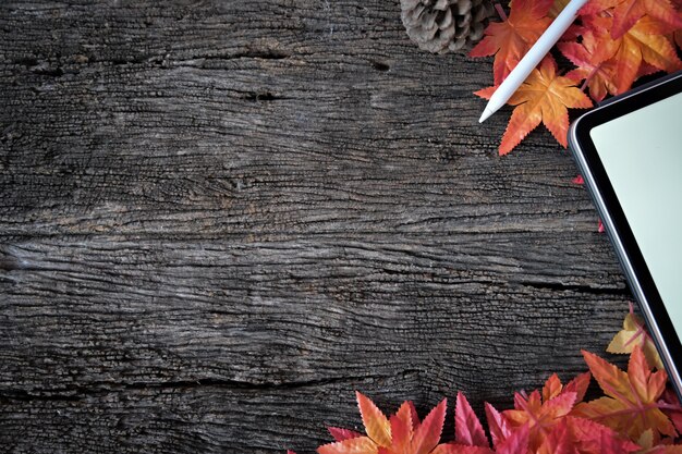 Textura de madera con hojas de arce, tableta maqueta y espacio de copia.