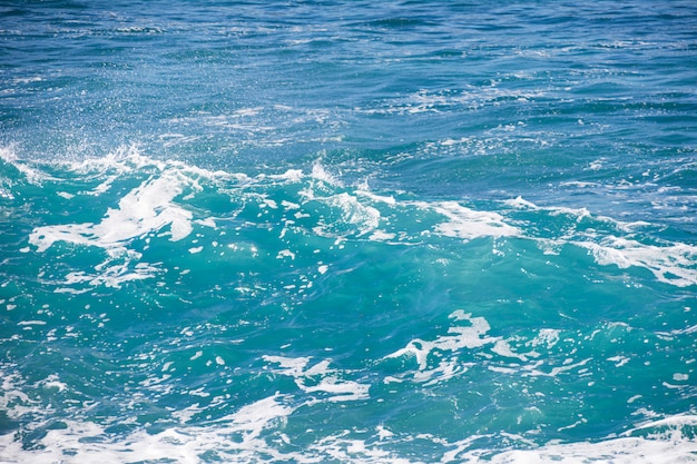 Foto textura de mar azul turquesa con olas y espuma.