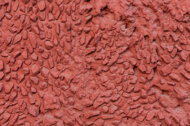 Textura de muro de hormigón rojo con piedras grandes