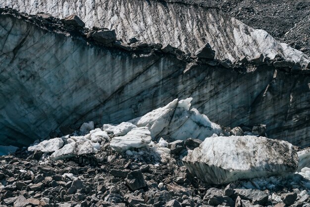 Textura natural da grande parede glacial com close-up de fendas. Natureza atmosférica com pedregulhos de gelo perto de parede quebrada gelada com rachaduras. Grande paz de gelo e pedras perto da superfície da geleira.