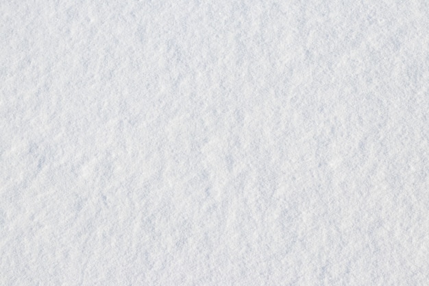 Textura de nieve fraccionada sobre una superficie plana, fondo de invierno