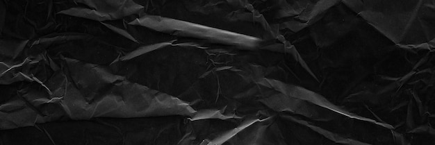 Textura de papel arrugado negro con pliegues Fondo de papel tapiz negro
