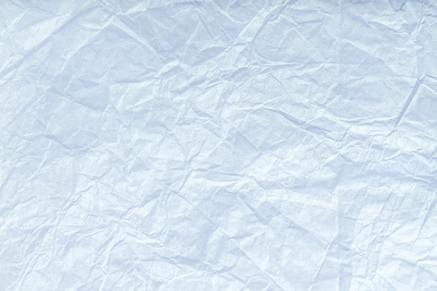 Foto textura del papel de embalaje azul claro arrugado, primer. fondo antiguo blanco