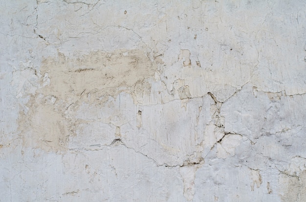 Textura de una pared de cemento gris con grietas y agujeros