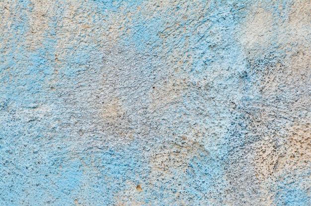 Textura de pared de cemento con restos de pintura azul.