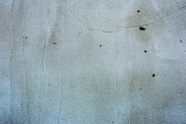 Textura, pared, fondo de hormigón. Fragmento de pared con arañazos y grietas.