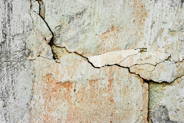 Textura, pared, fondo de hormigón. Fragmento de pared con arañazos y grietas.