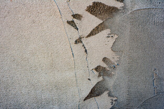 Textura, pared, hormigón, se puede utilizar como fondo. Fragmento de pared con rasguños y grietas.