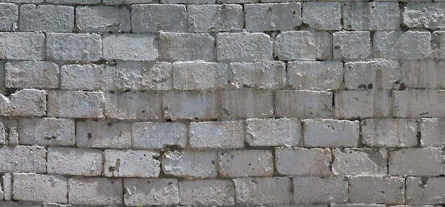 Textura de la pared de ladrillo de piedras de alivio bajo luz del sol brillante