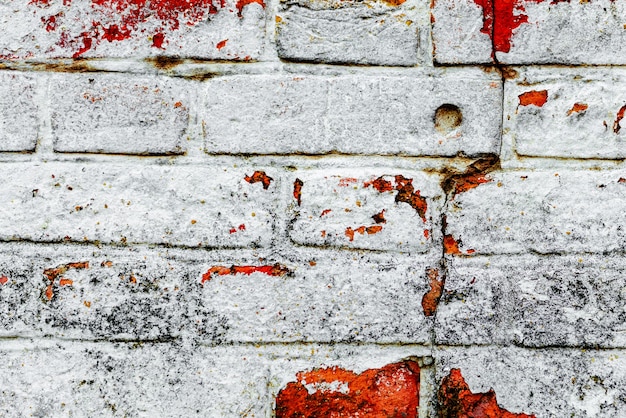 Textura de una pared de ladrillos con grietas y arañazos que se pueden utilizar como fondo