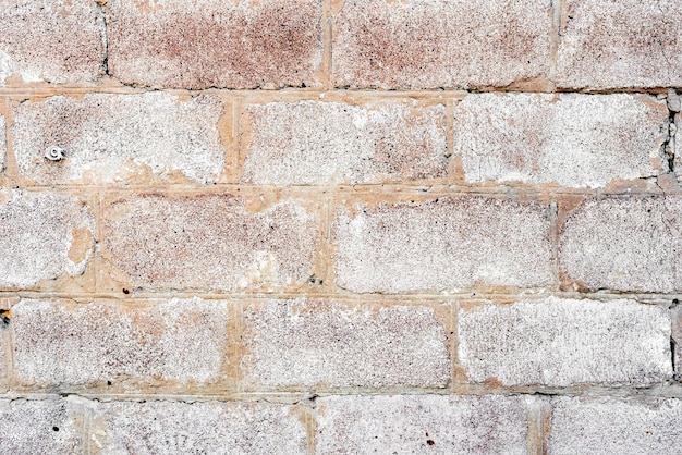 Textura de una pared de ladrillos con grietas y rasguños que se pueden utilizar como fondo