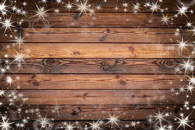 Textura de pared de madera marrón con nieve blanca y estrellas Fondo de Navidad