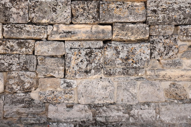 Textura de pared de piedra con muchas piedras marrones grandes