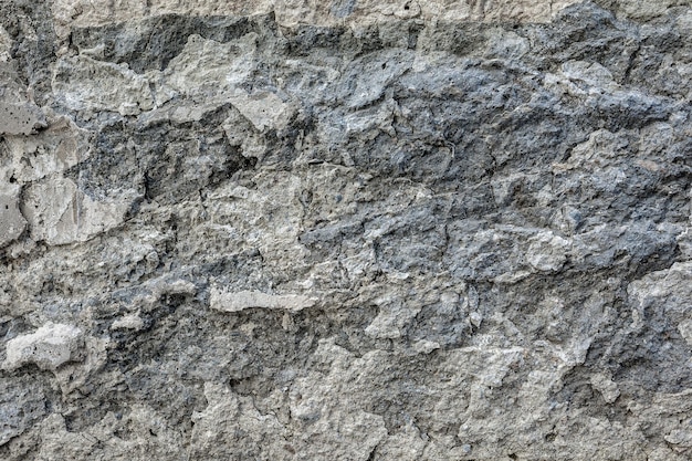 Textura y patrón del yeso destruido en una pared de piedra