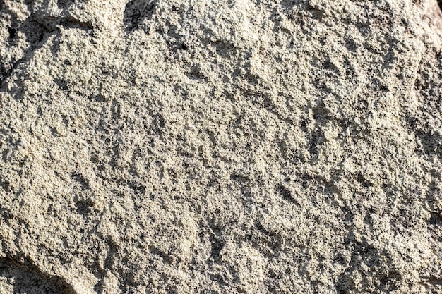 Textura de piedra arenisca con grano e irregularidades a la luz del sol