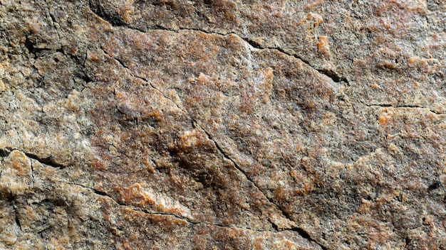 Textura de piedra de granito. Superficie de roca de granito agrietada. Telón de fondo de piedra natural. De cerca