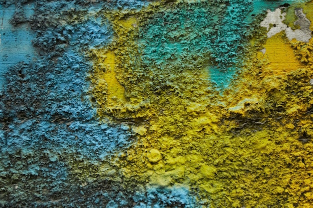 Textura de piedra pintada con colores de la bandera ucraniana Rayas de color amarillo azul pintura en la superficie de la pared de piedra caliza áspera