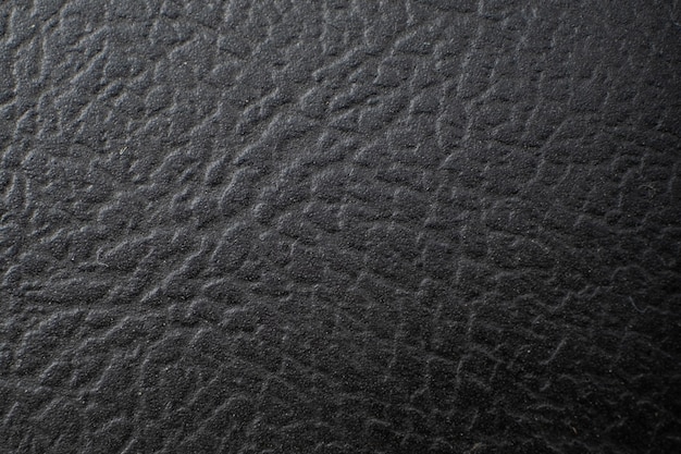 Textura de piel oscura en relieve, fondo de cuero negro.