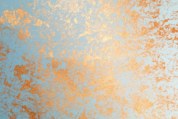 Textura de pintura dorada sobre papel azul