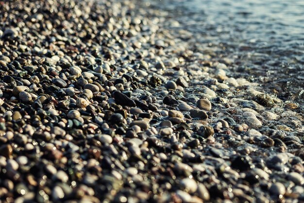 Textura de playa de piedras de guijarros grises en el mar como fondo