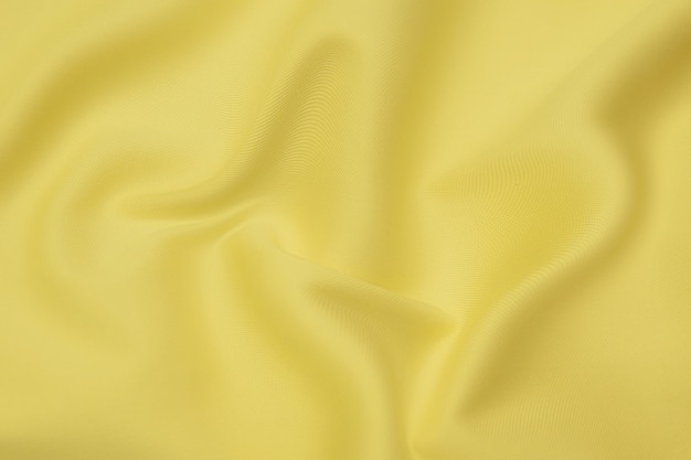 Textura de primer plano de tela o paño naranja o amarillo natural del mismo color. Textura de tela de algodón natural, seda o lana, o material textil de lino. Fondo de lienzo amarillo.