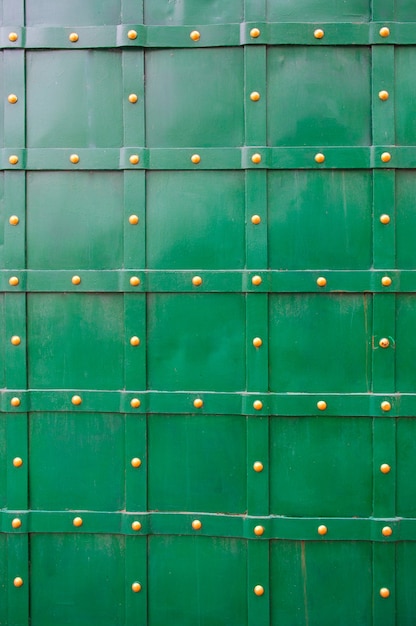 Textura de puerta de metal viejo verde con remaches