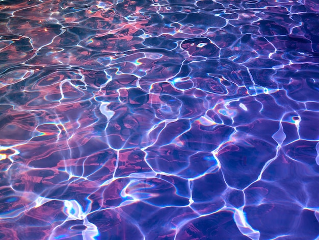 Textura púrpura abstracta del agua de la piscina con reflejos