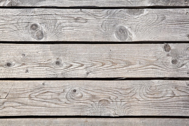 Textura resistida do deck de madeira do caminho nas dunas cobertas de areia