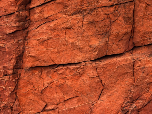 Textura de roca de color marrón naranja oscuro con grietas de primer plano Superficie de montaña áspera Piezas de granito