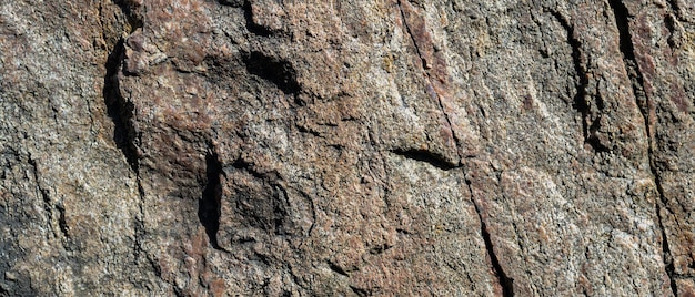 Textura de roca de granito. Superficie de granito agrietada por la intemperie. Primer plano de la superficie de la piedra. Concepto de color de la tierra