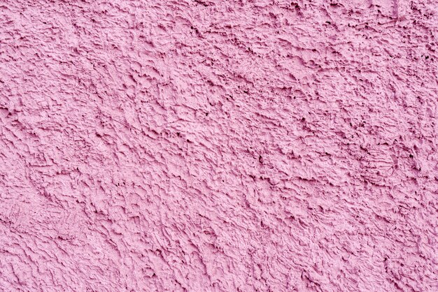 Textura rosada de yeso desigual en la pared de la casa.