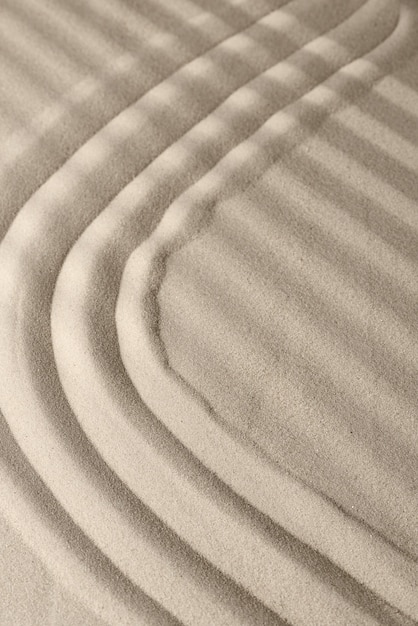 Textura de superficie de arena con líneas suaves y sombras.