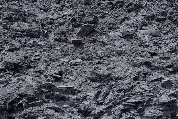 La textura de la superficie de piedra de la montaña con minerales en colores monocromáticos de negro y gris. Concepto de fondo, textura