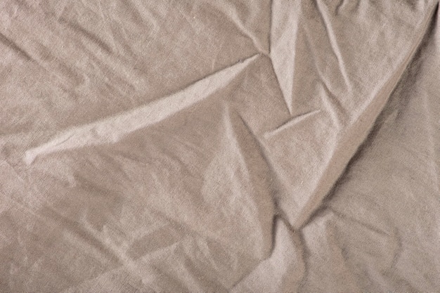 La textura de la tela arrugada es una tela gris oscuro con grandes pliegues en la parte superior para textura o