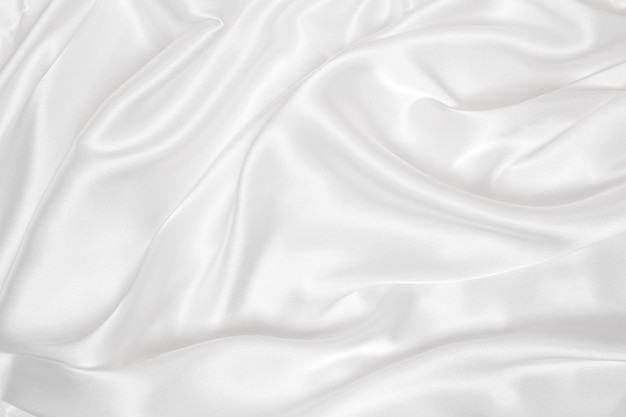 La textura de tela de lujo de seda blanca o satén elegante y suave se puede usar como fondo de boda Diseño de fondo de lujo