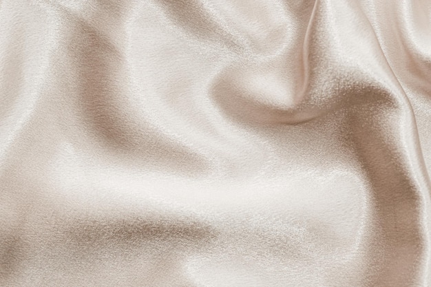 Textura de tela de seda beige Fondo de moda satinada para contenido