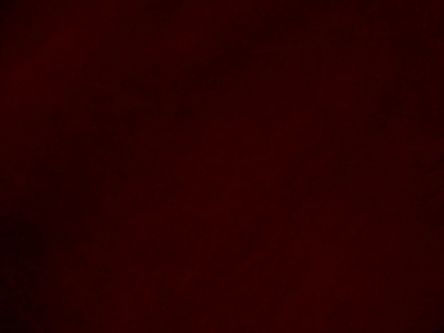 Foto textura de tela de terciopelo rojo oscuro utilizada como fondo fondo de tela rojo oscuro vacío de material textil suave y liso hay espacio para texto