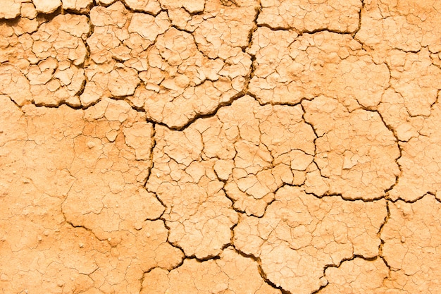 Textura de la tierra o tierra seca del suelo agrietado durante la sequía.