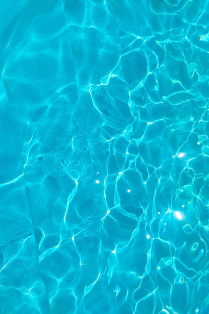 Foto textura transparente azul del agua en una piscina azul con salpicaduras del sol