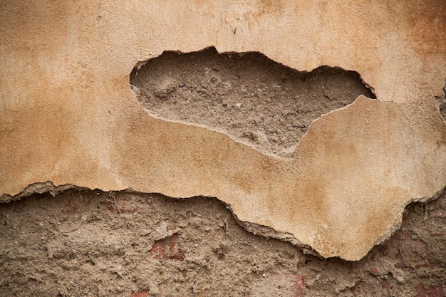 Textura de una vieja pared irregular Fondo de ladrillos viejos y grietas en yeso Tonos amarillos y marrones