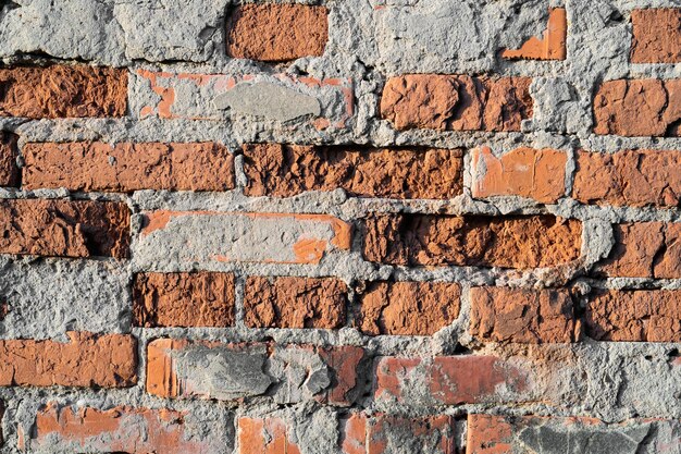 Foto textura de la vieja pared de ladrillo rojo agrietada y destruida