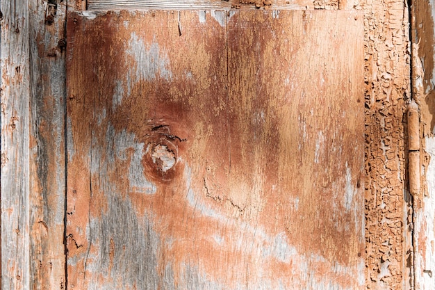 Textura de la vieja pared de madera en mal estado marrón con pintura descascarada y agrietada