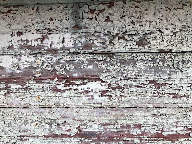 Textura de una vieja pared de madera en ruinas de color gris negro una cerca con pedazos de viejo exfoliado en mal estado