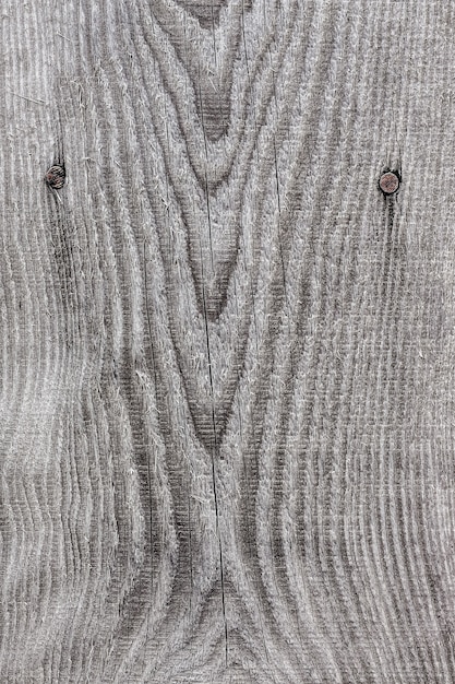 Textura de una vieja tabla de madera con grietas de color gris y marrón