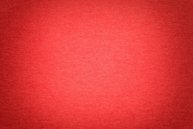 Textura del viejo fondo de papel rojo brillante, primer. Estructura de cartón denso.