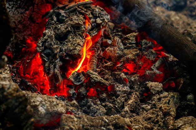 Texturflamme aus brennenden Holzstämmen in der Nacht