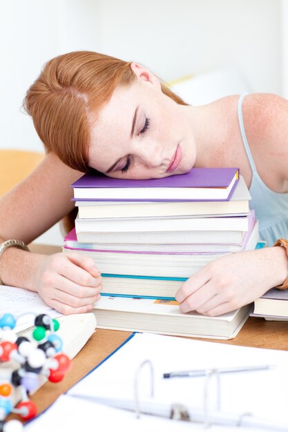 Teyerager cansado dormindo em livros