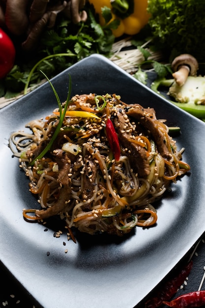 Thailändische Cousine. Rezept für Reisnudeln mit Schweinefleisch und Gemüse. Lebensmittelzutaten und Kochprozess.