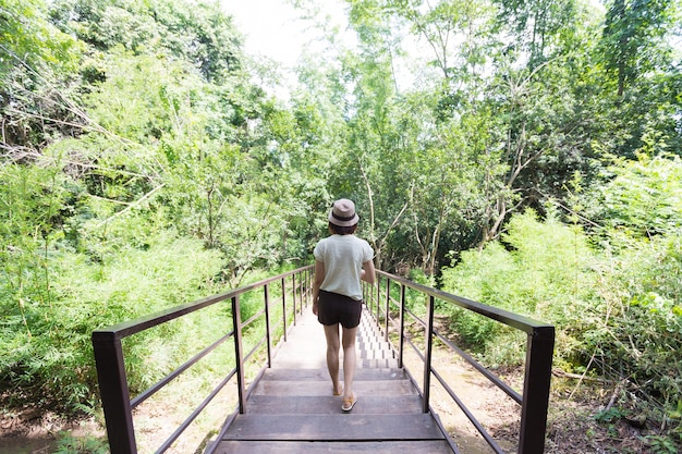 Thailändische Frau, die auf die Brücke geht